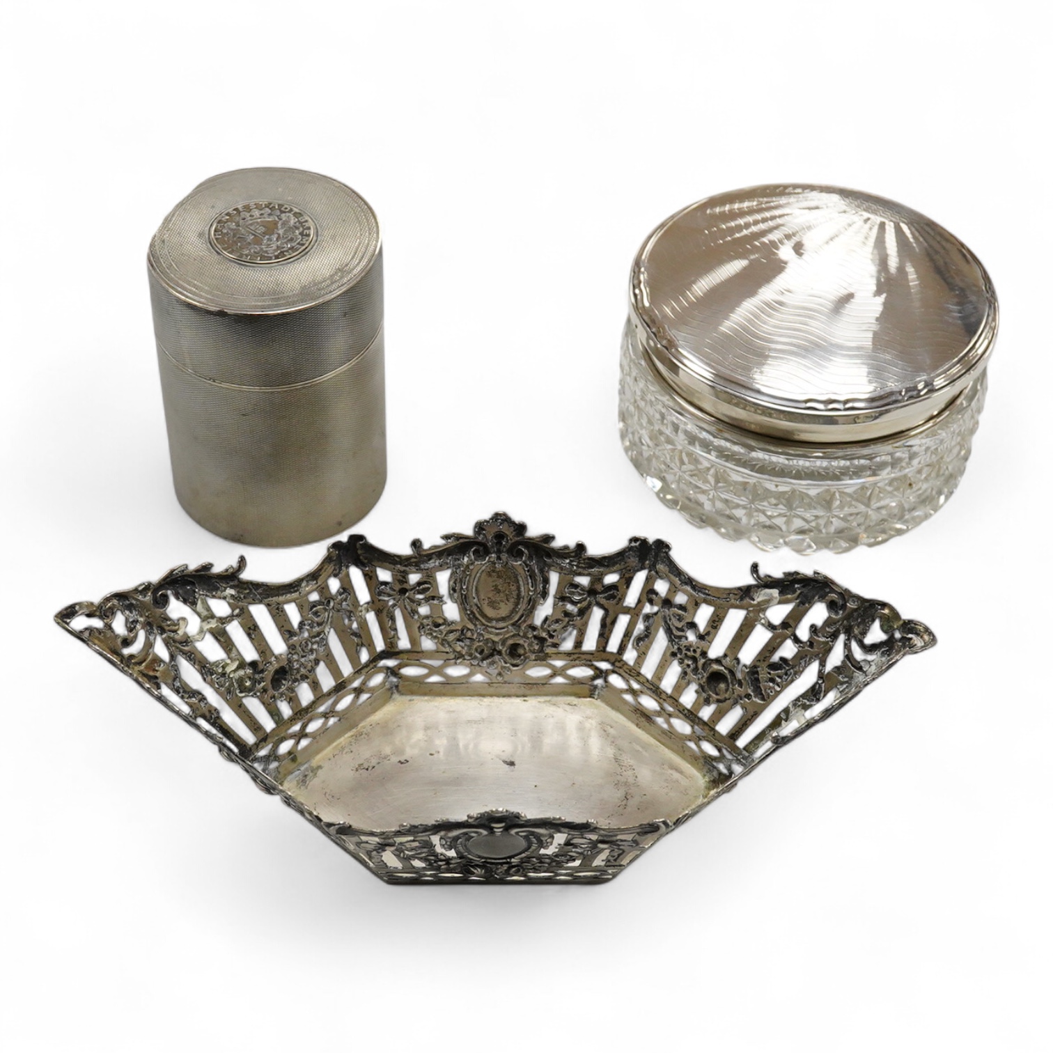 A German pierced 800 standard white metal bowl, 21.2cm, an engine turned white metal cigarette canister and a silver mounted glass dressing table pot.